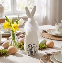 Produkt Ceramiczny króliczek w kolorze białym, ozdobne piórka, kwiaty Ø6cm W20,5cm